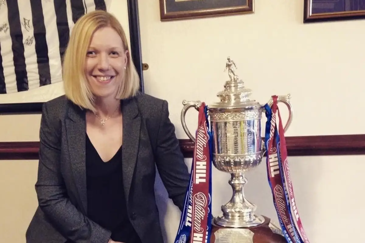 woman posing with large silver trophy